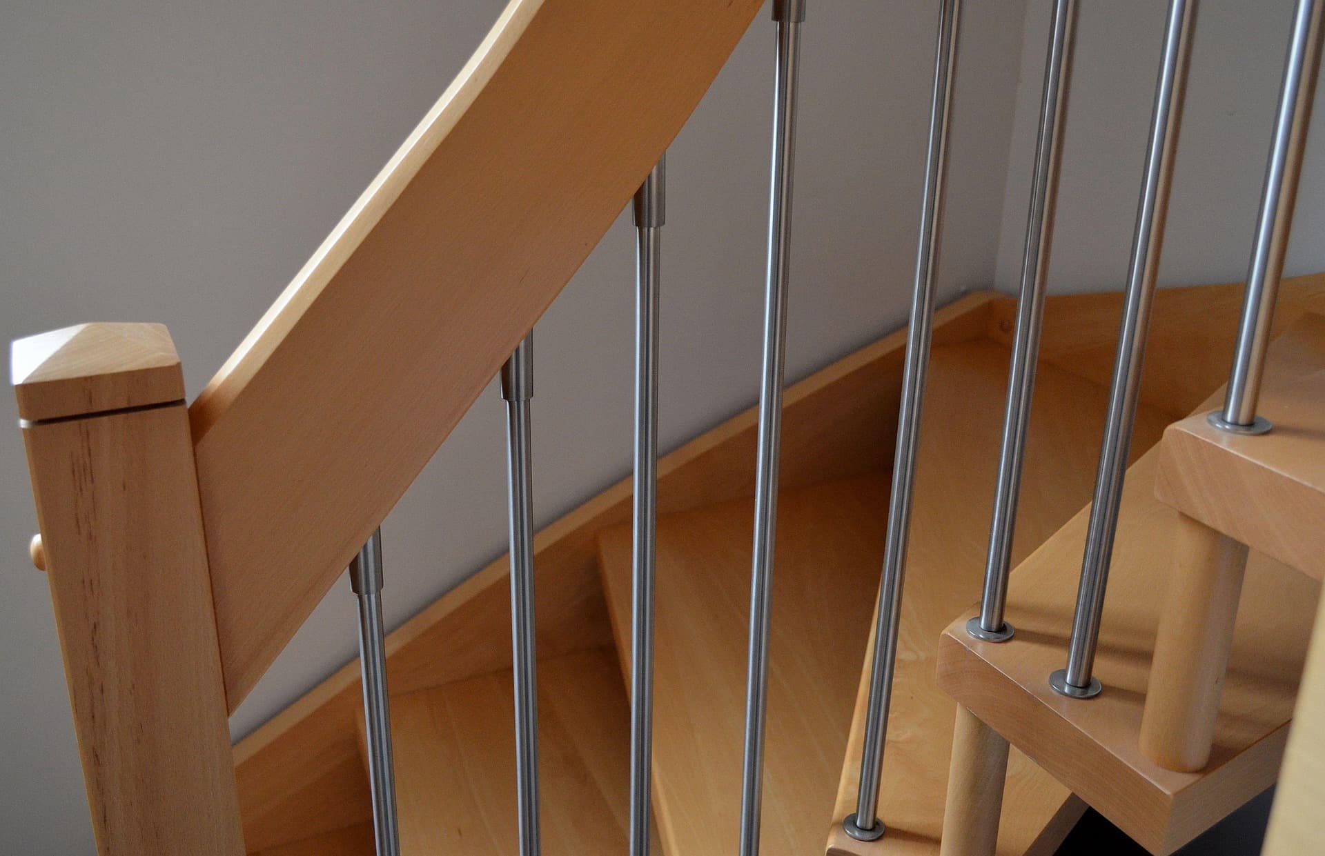 Escalier en bois clair avec garde-corps à barreaux inox